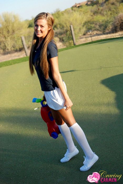 девушка с выбритой киской Craving Carmen в белой мини юбке развлекается сама с собой на гольф-лужайке